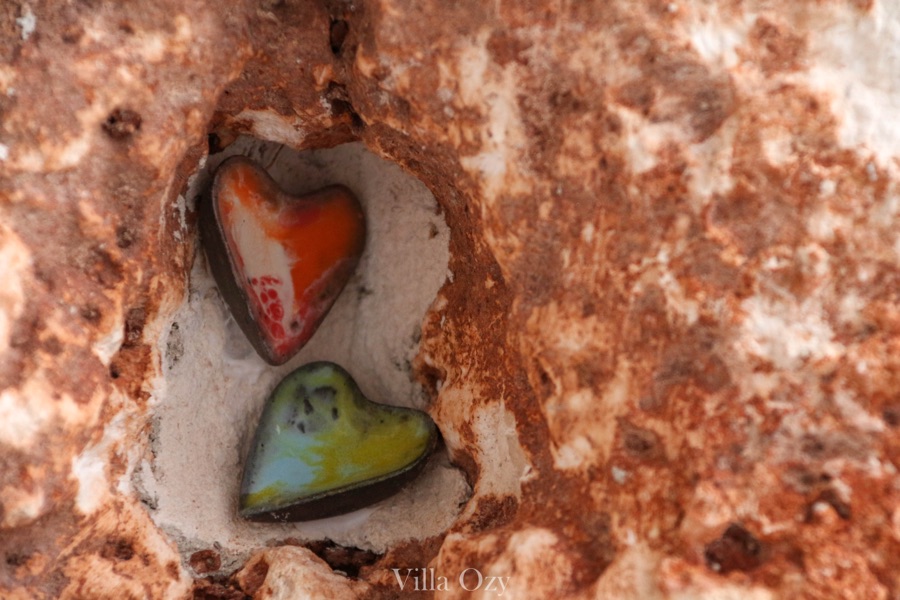 Two small ceramic hearts set into a limestone niche